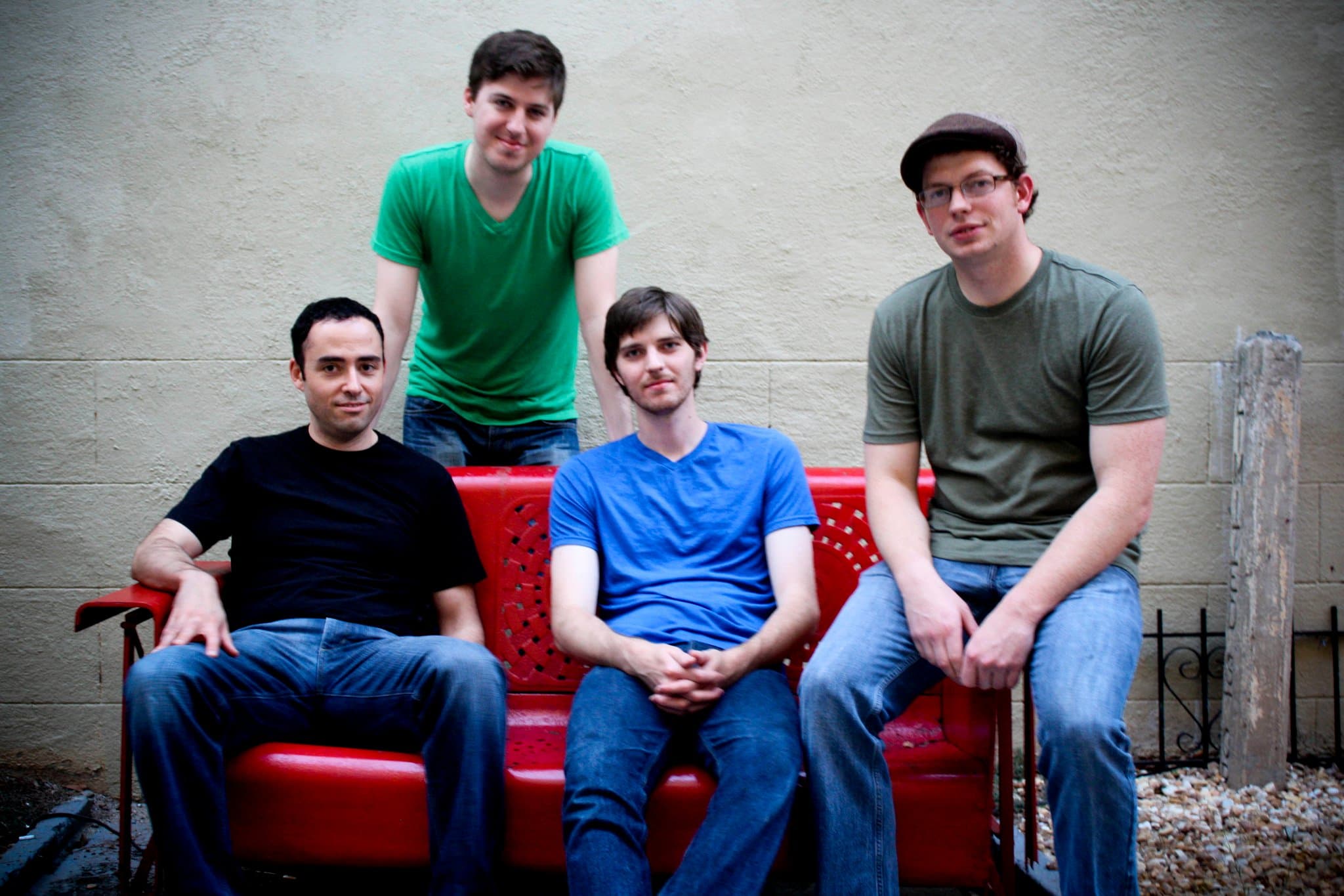 The Dirty Souls in 2010 — Matt Johnson, Jason Holt, Adam Johnson and Alex Slinin on a red bench against a painted cinderblock wall.
